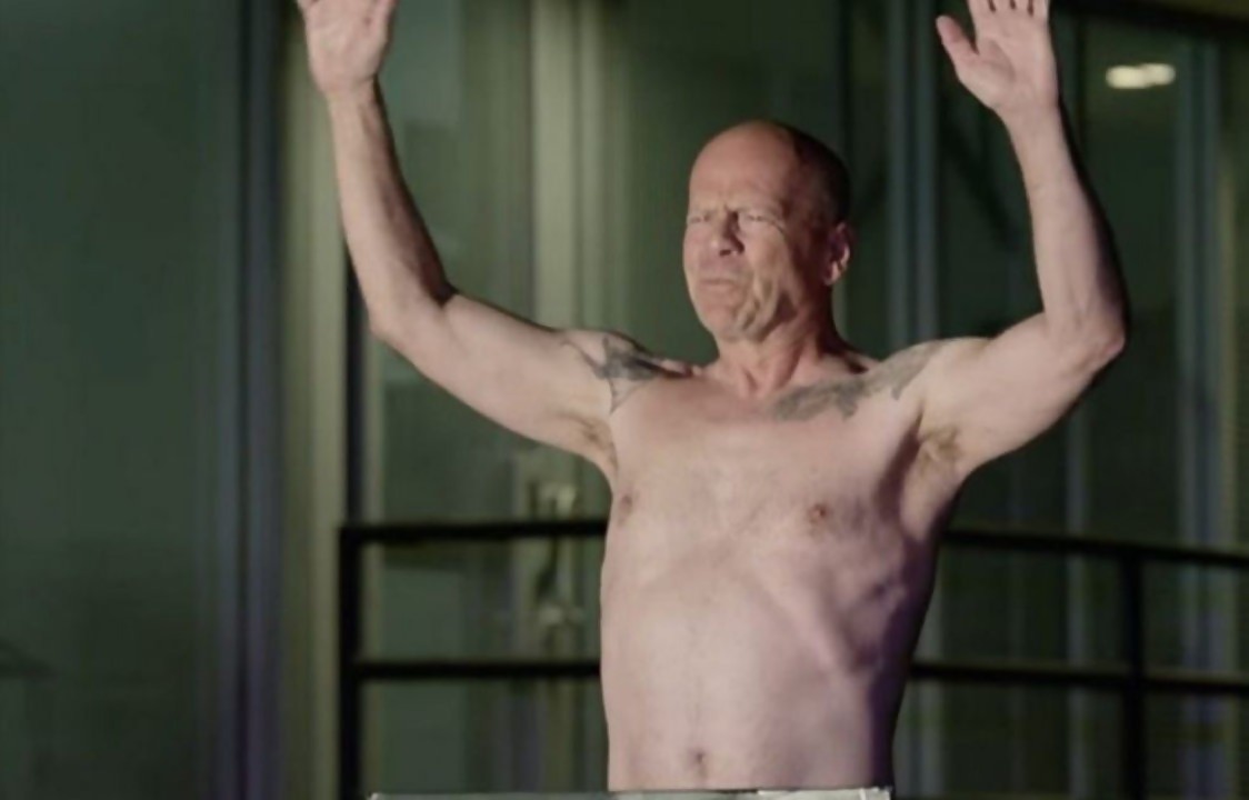 Bruce Willis nu sur un skate en mode John Wick face à Jason Momoa.